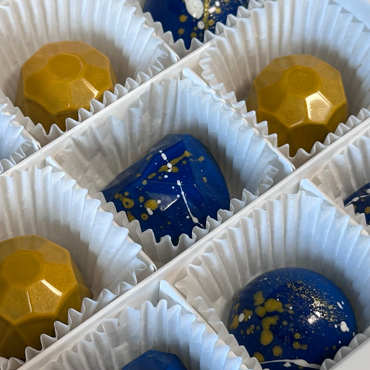 Макрозйомка синьої серцевидної та золотої гранованої цукерок JOY BOX із золотими крапками (набор 9 шт.)